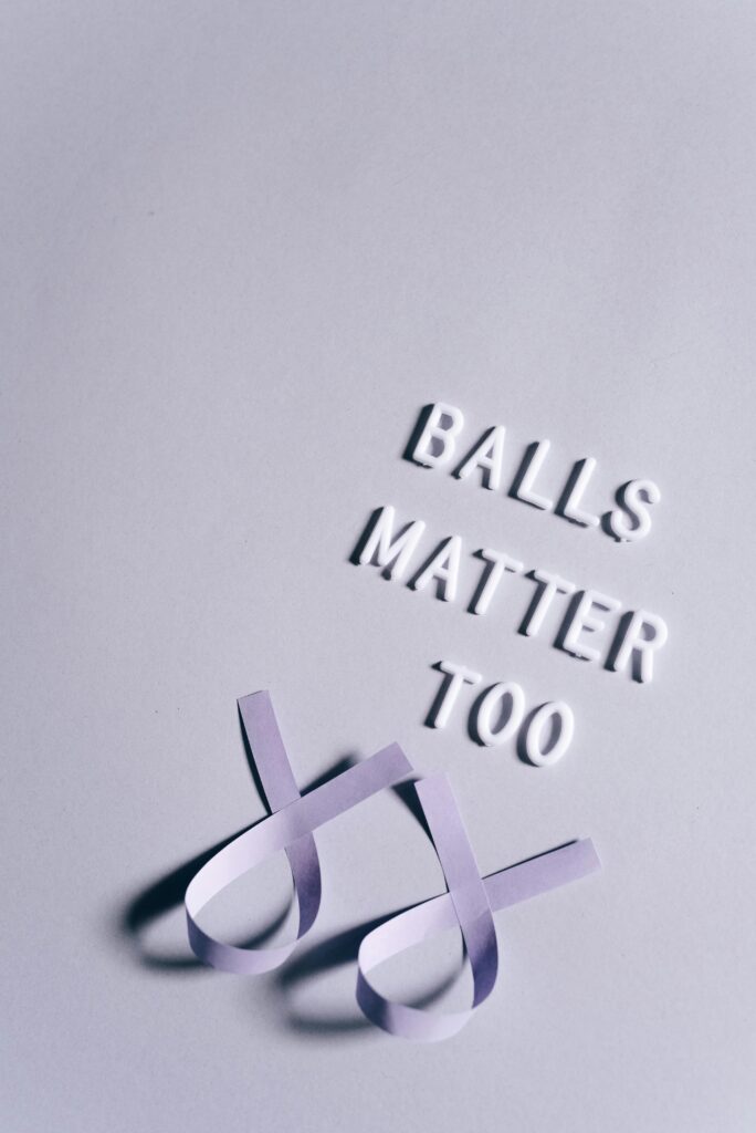 Vertical shot of a slogan 'Balls Matter Too' with ribbons for cancer awareness.